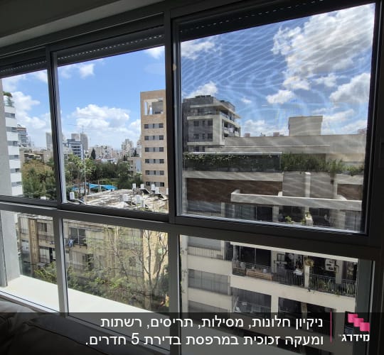 חלון נקי עם נוף עירוני ברקע